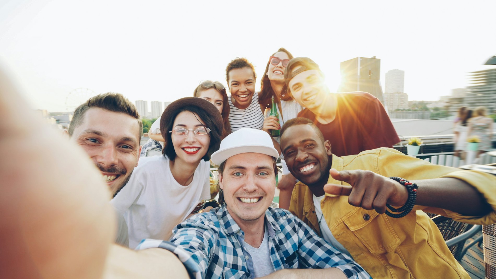 A group of friends of several backgrounds crowded together, laughing